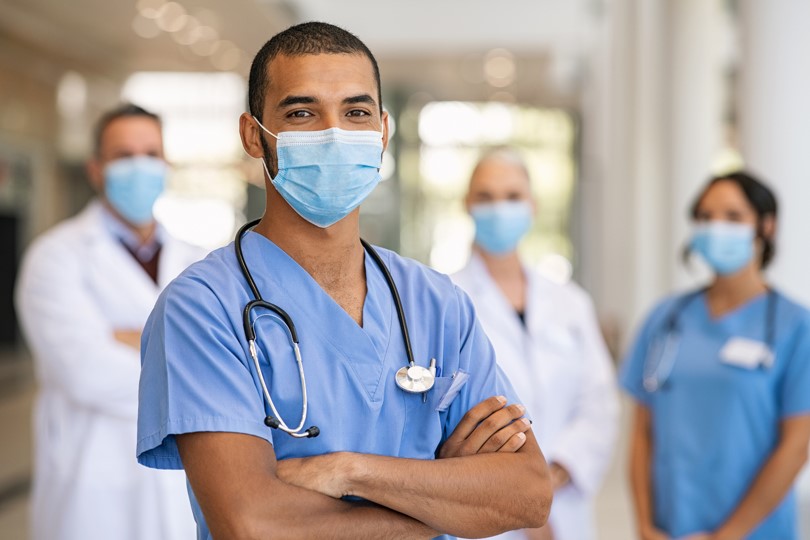 Team of surgeons and nurses in scrubs and white coats