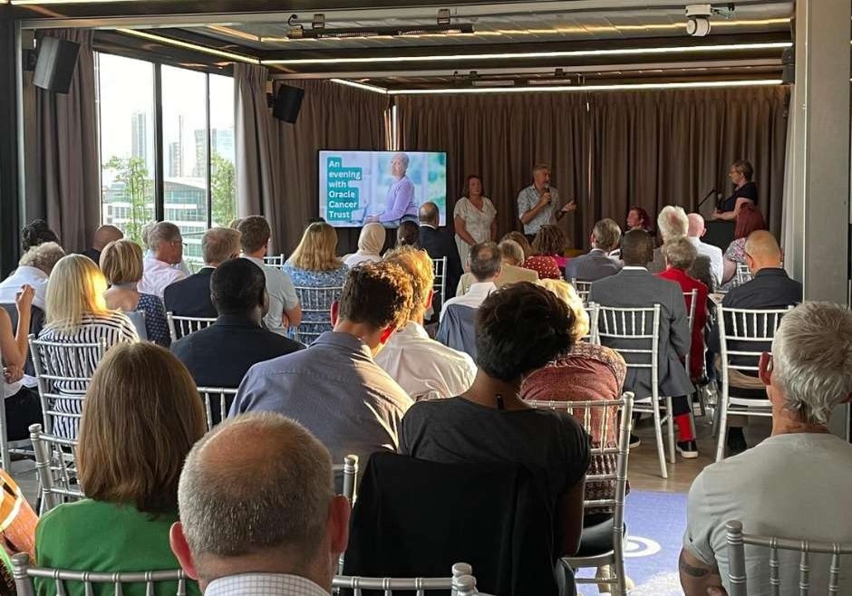 Event photo with room filled with people sitting listening to panel discussion