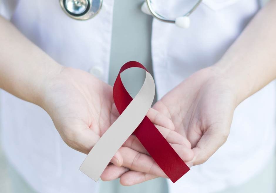 Healthpractitioner with Head and Neck cancer ribbon in hands