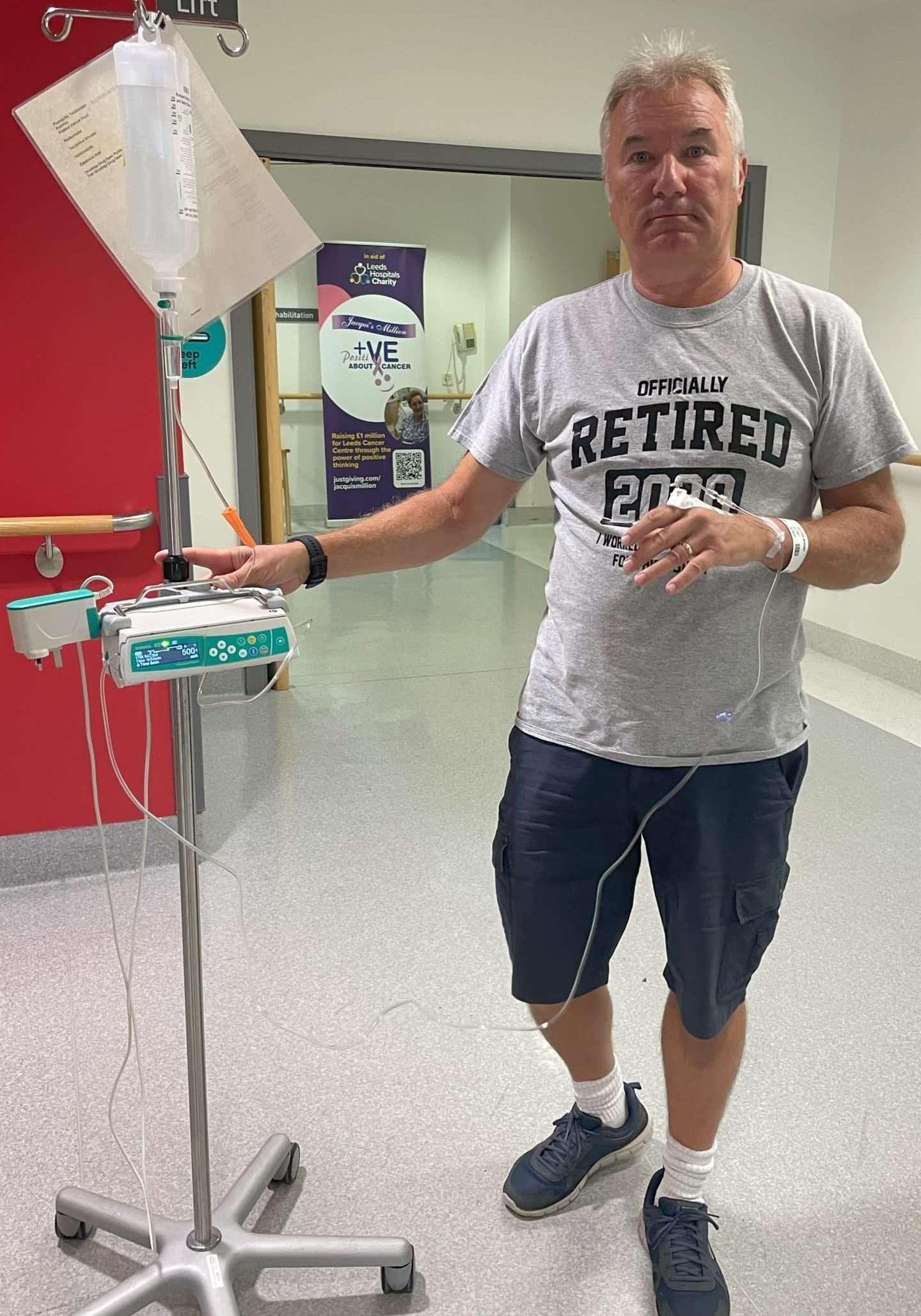 Patient wheeling his chemotherapy drip on the ward.